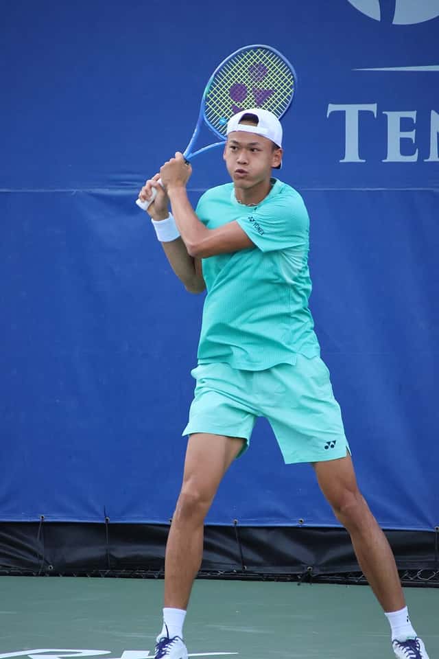 Foto de archivo: Rei Sakamoto, con gorra blanca puesta al revés y conjunto verde agua, prepara un golpe a dos manos frente a una lona azul, en un torneo de 2026 en Cary, Estados Unidos