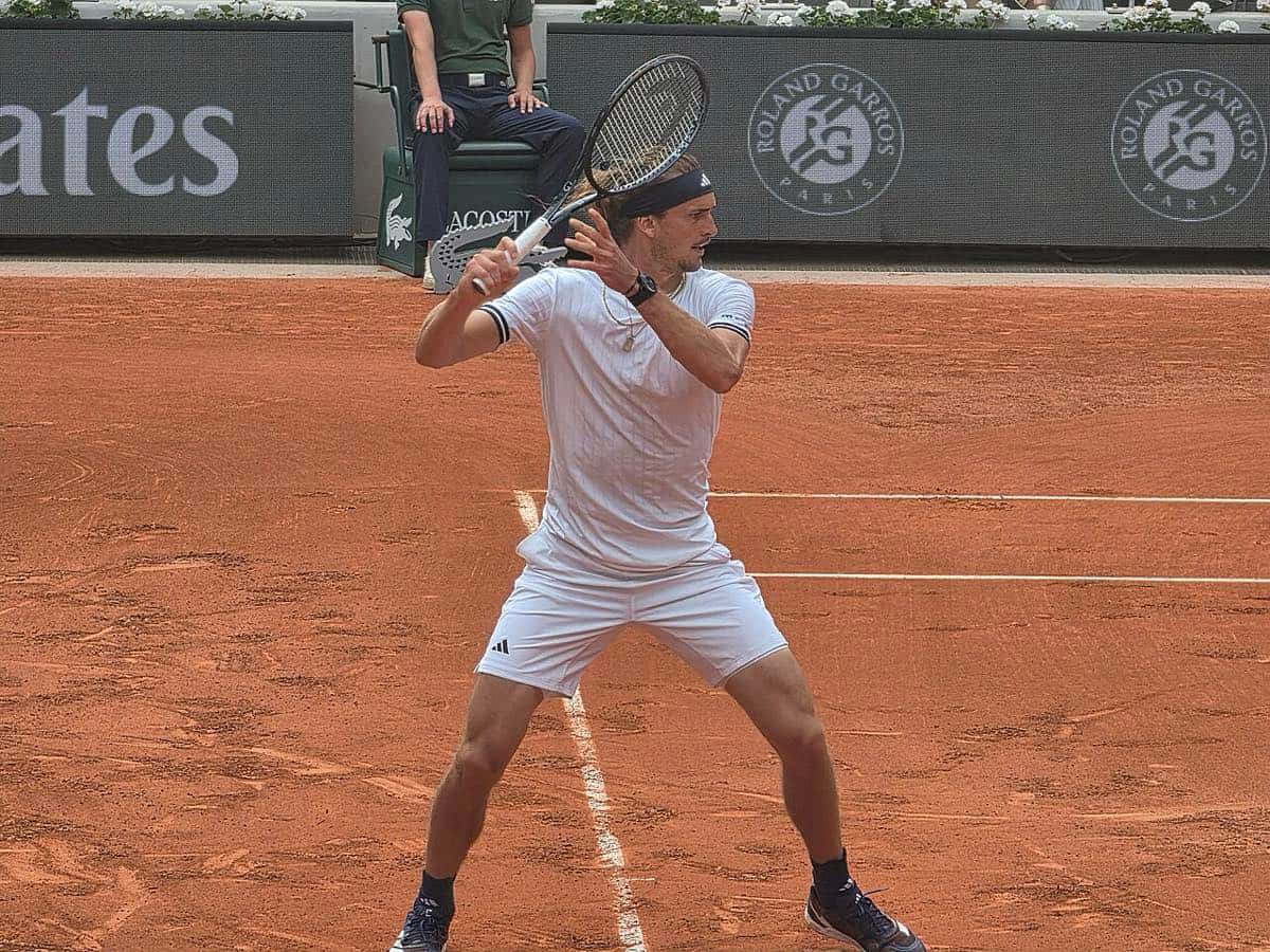 Foto de archivo: Alexander Zverev, de blanco y con vincha, prepara un drive a dos manos en el polvo de ladrillo de Roland Garros 2026