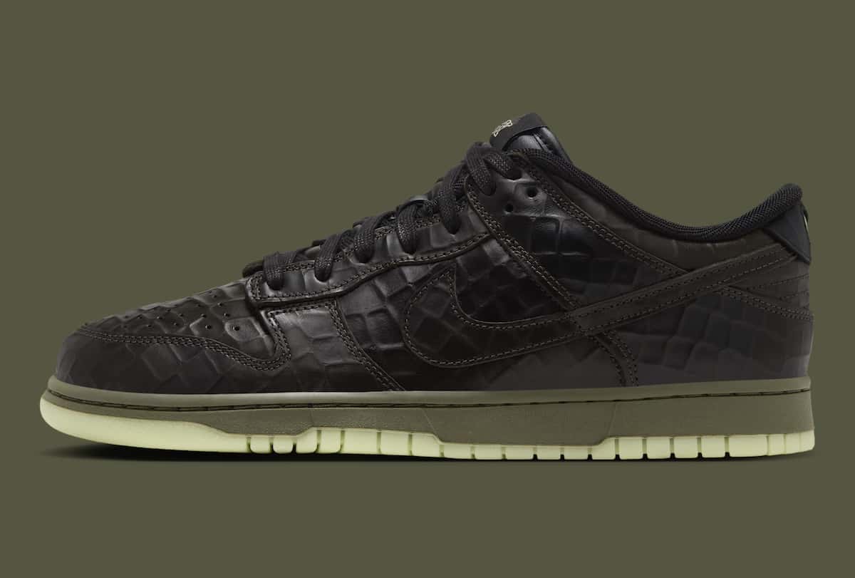 Nike Dunk Low Shibuya Halloween de perfil sobre fondo verde oliva, con upper de cuero negro texturado tipo cocodrilo, mediasuela verde oliva y suela verde clara