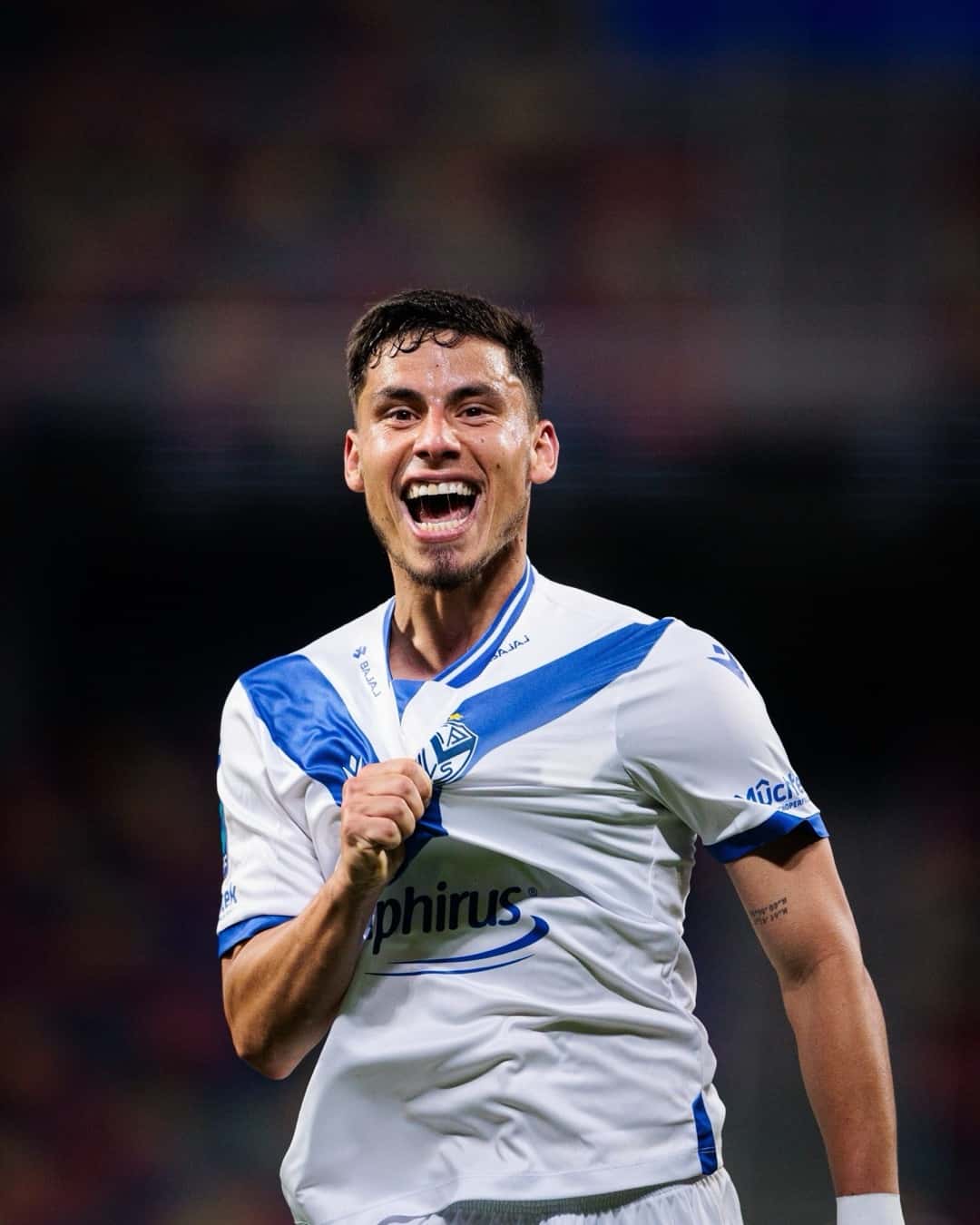 Un jugador de Vélez, con la camiseta blanca con la V azul, sonríe y se toma la camiseta para festejar un gol; foto de archivo de octubre de 2026 (foto: prensa Liga Profesional de Fútbol)