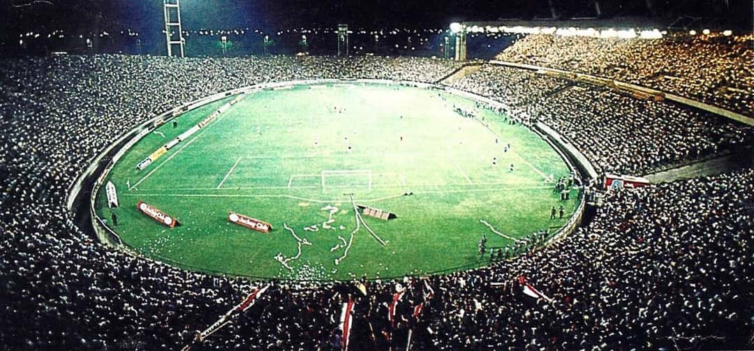 El estadio José María Minella de noche, con las tribunas llenas durante un partido entre Boca y River; foto de archivo de enero de 1987, dominio público, Wikimedia Commons