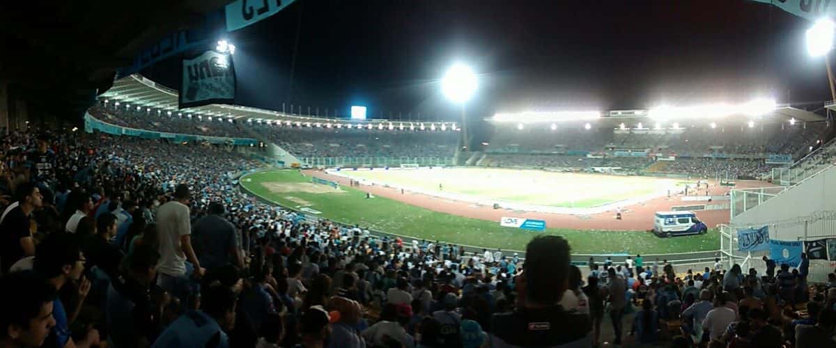 Una tribuna llena de hinchas de Belgrano en el estadio Mario Alberto Kempes, de Córdoba, durante el entretiempo de un partido nocturno; foto de archivo de febrero de 2016 (foto: Alepizarro32, Wikimedia Commons, licencia CC BY-SA 4.0)