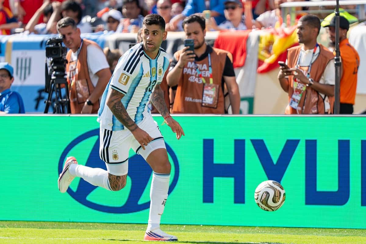 Cristian Romero, con la camiseta de la Selección argentina, conduce la pelota junto a la línea lateral; foto de archivo de la final del Mundial 2026 ante España (foto: Bryan Berlin, Wikimedia Commons, licencia CC BY-SA 4.0)