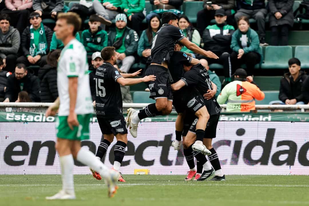 Los jugadores de Argentinos Juniors, con la camiseta negra de visitante, festejan un gol saltando y abrazados en la cancha de Banfield, con la tribuna local de fondo; foto de archivo del 17 de octubre de 2026 (foto: prensa oficial de Argentinos Juniors)