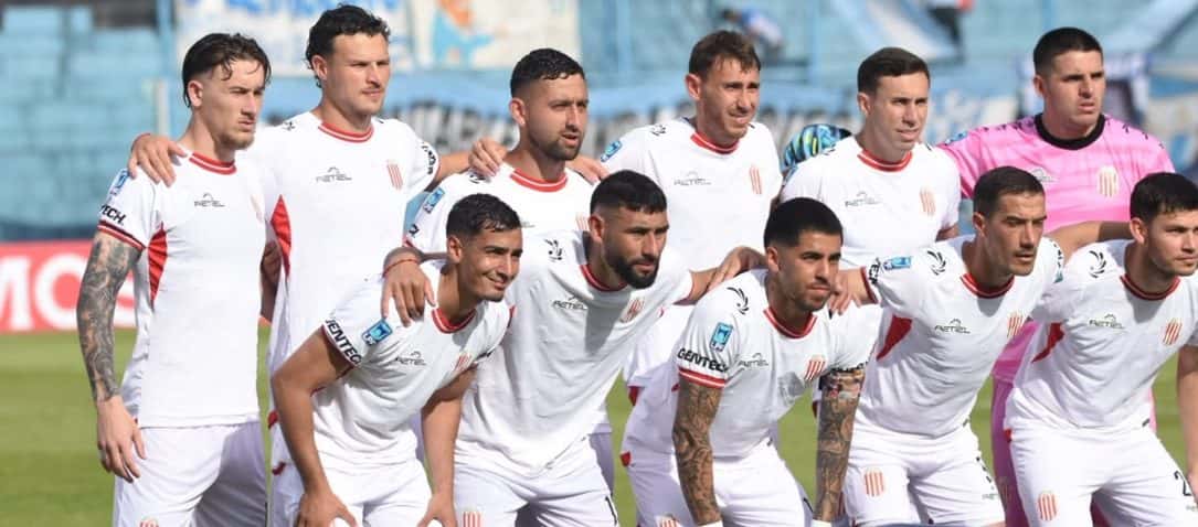 Los once titulares de Barracas Central, con camiseta blanca, posan para la foto antes del partido ante Atlético Tucumán en el estadio José Fierro