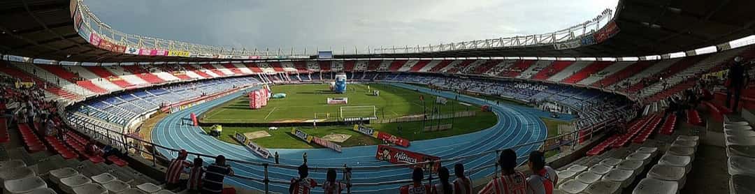 Vista panorámica del Estadio Metropolitano Roberto Meléndez de Barranquilla desde la tribuna, con la pista de atletismo azul alrededor de la cancha; foto de archivo de 2016 (foto: Sampués, Wikimedia Commons, licencia CC BY-SA 4.0)