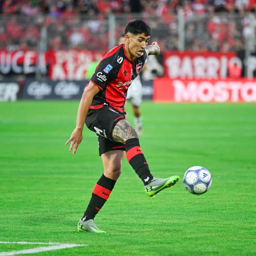 Un jugador de Newell's, con la camiseta rojinegra, prepara un pase con la zurda en el estadio Marcelo Bielsa, con la tribuna local de fondo, durante la fecha 13 del Clausura (foto: Liga Profesional de Fútbol)