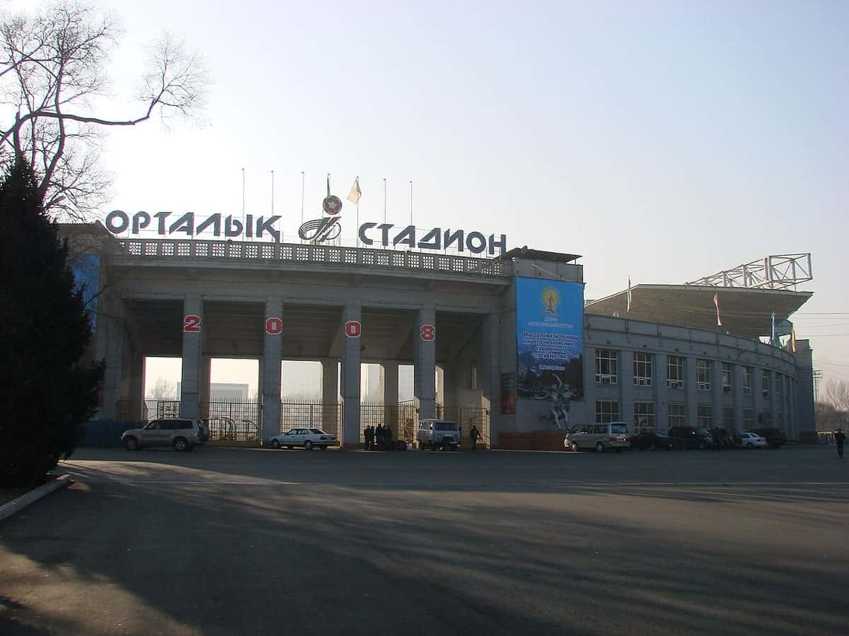 La entrada del estadio Central de Almaty, en Kazajistán, con su columnata y el nombre del estadio en letras grandes sobre el frente; foto de archivo de 2008 (foto: Дмитрий Никишин, Wikimedia Commons, dominio público)