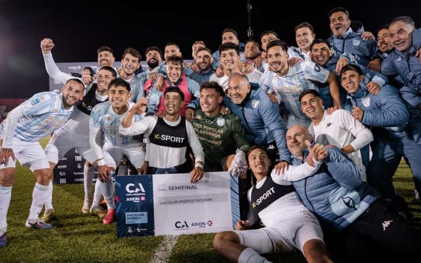 Jugadores y cuerpo técnico de Atlético Tucumán festejan con el cartel oficial de semifinalista de la Copa Argentina