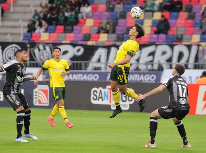 Un jugador de Defensa y Justicia, con la camiseta amarilla y el número 10, cabecea la pelota en un partido del Clausura 2026 en Santiago del Estero