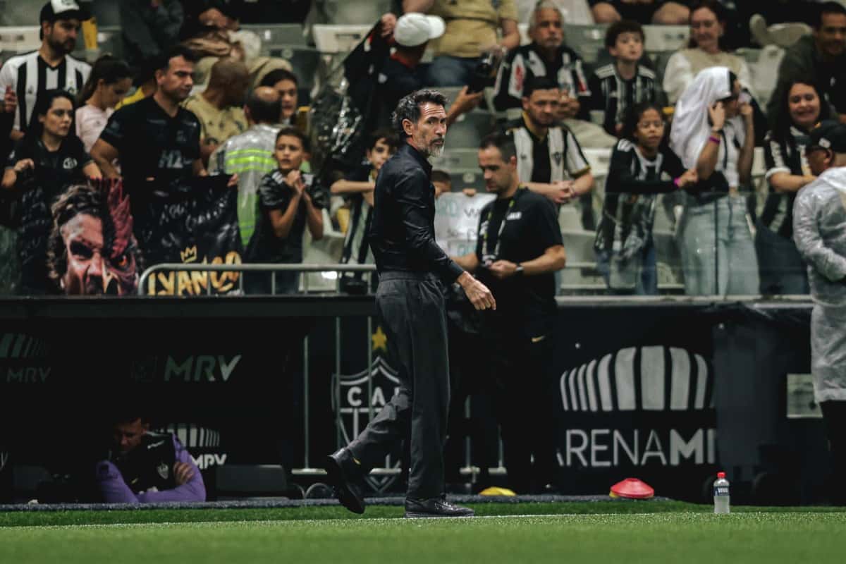 Eduardo Domínguez, técnico de Atlético Mineiro, vestido de negro, camina junto al costado de la cancha de la Arena MRV con la hinchada de fondo (foto: prensa oficial de Atlético Mineiro)