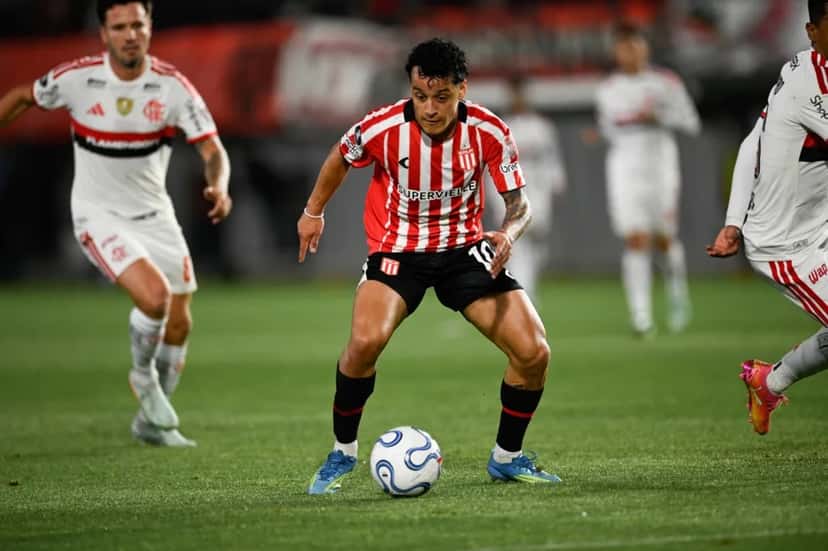 Un jugador de Estudiantes con la camiseta albirroja y el número 10 conduce la pelota mientras lo rodean futbolistas de Flamengo de blanco, en el estadio UNO de La Plata (foto: prensa oficial de Estudiantes de La Plata)