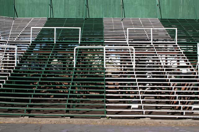 La vieja tribuna de Ferro sobre la calle Martín de Gainza, con escalones de madera y barandas blancas, vacía; foto de archivo de 2012 (foto: Facundo Diez, Wikimedia Commons, licencia CC BY-SA 3.0)