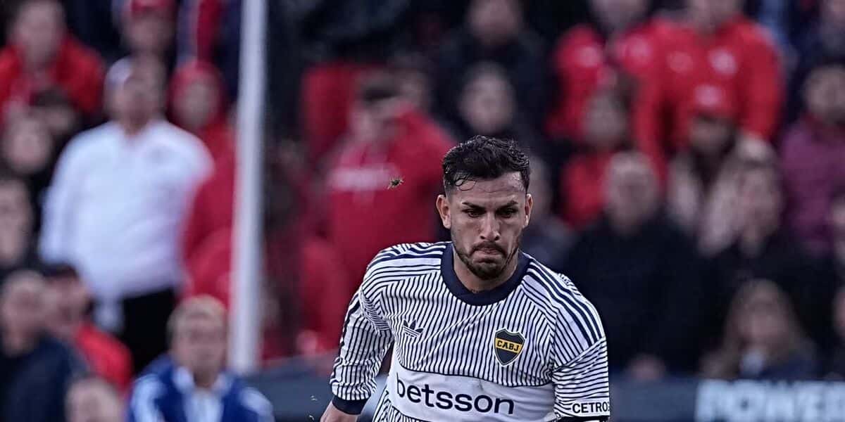 Leandro Paredes, con la camiseta blanca de rayas azules de Boca, maneja la pelota en el estadio de Independiente, con la tribuna roja de fondo; foto de archivo del 25 de octubre de 2026 (foto: prensa Boca Juniors)