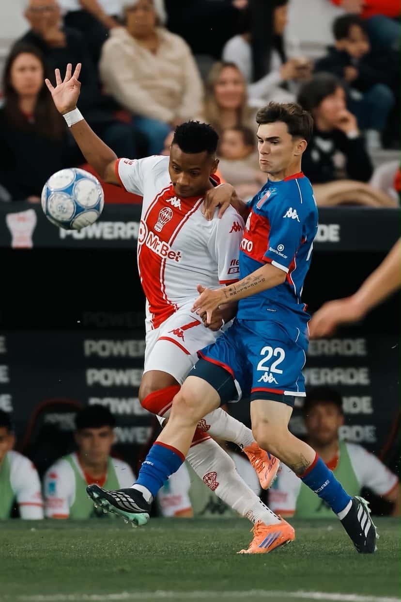 Un jugador de Tigre, con la camiseta azul y el número 22, pelea la pelota con un jugador de Huracán de camiseta blanca y roja, en el Ducó el viernes 30 de octubre (foto: prensa Liga Profesional de Fútbol)