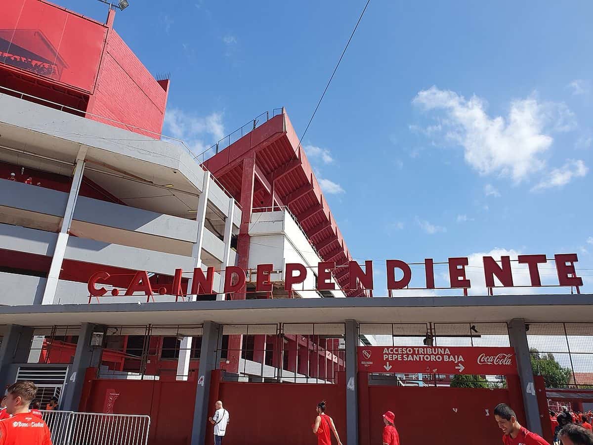 La entrada del estadio Libertadores de América-Ricardo Enrique Bochini, de Independiente, con el nombre del club en letras rojas y las tribunas detrás; foto de archivo (foto: Leandogo, Wikimedia Commons, licencia CC BY-SA 4.0)