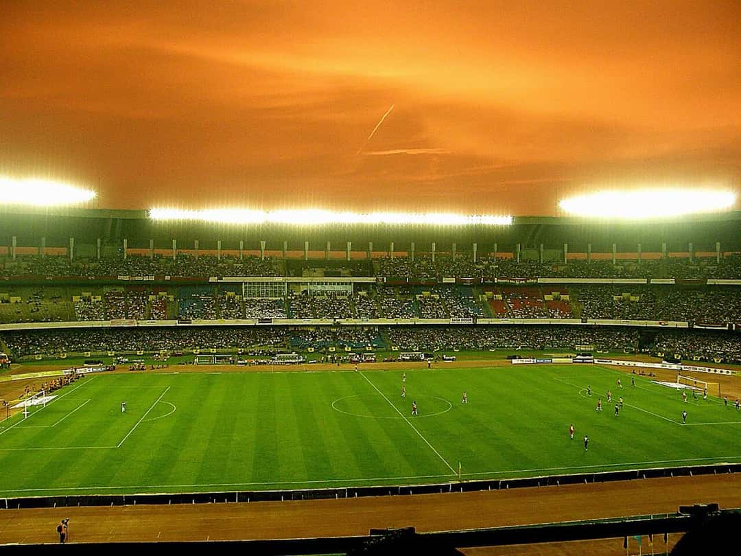 Vista panorámica del estadio Salt Lake de Calcuta, con la cancha iluminada y las tribunas llenas, durante un partido en 2008. Foto: Lovedimpy, dominio público, vía Wikimedia Commons
