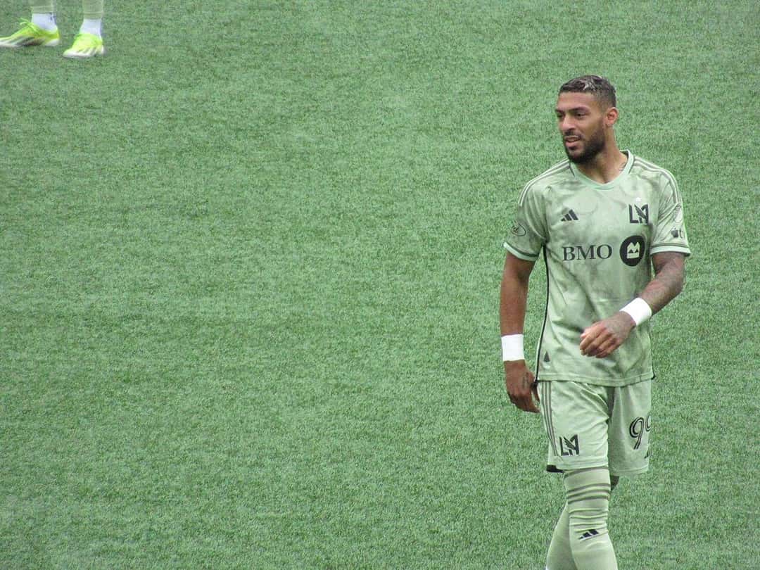 Denis Bouanga, con la camiseta verde de LAFC y el número 99, camina por el campo durante un partido de la MLS; foto de archivo de abril de 2024 (foto: Frenchieinportland, Wikimedia Commons, licencia CC BY 4.0)