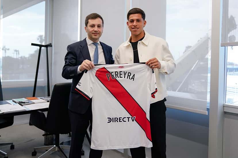Lautaro Pereyra y el presidente de River, Stefano Di Carlo, sostienen una camiseta blanca con la banda roja y el apellido Pereyra en la espalda, en una oficina del Monumental (foto: prensa River Plate)