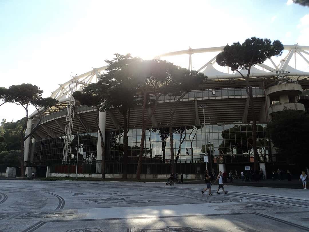 El exterior del Estadio Olímpico de Roma, con su techo blanco y los pinos de la explanada delante; foto de archivo de 2012 (foto: Nicholas Frisardi, Wikimedia Commons, licencia CC BY-SA 3.0)
