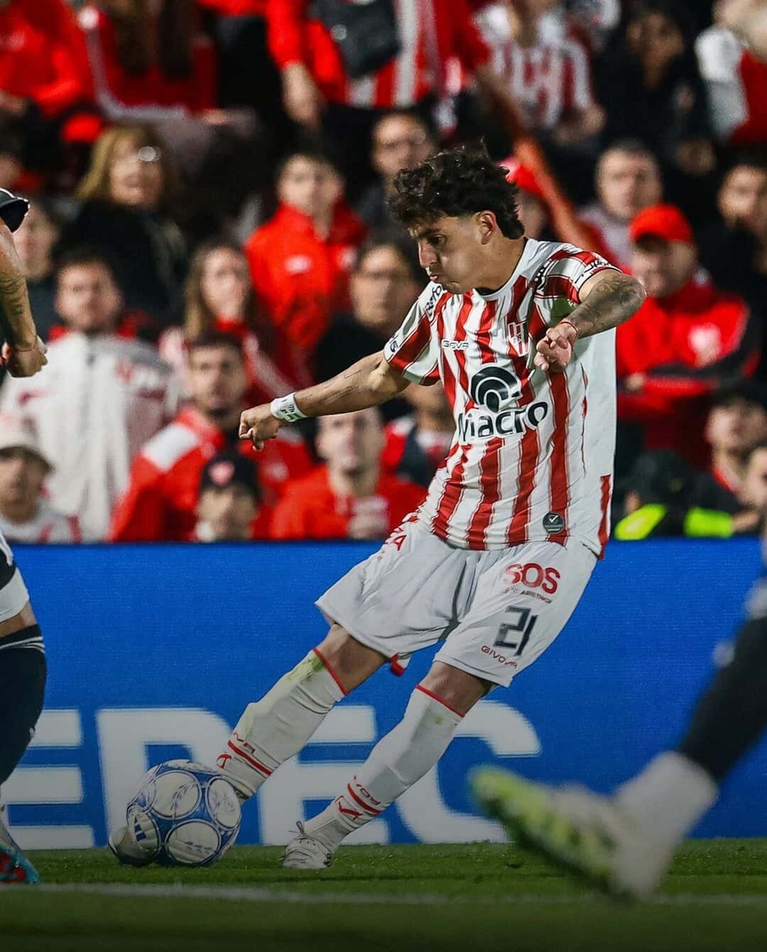 Un jugador de Instituto, con la camiseta blanca y roja y el número 21, le pega a la pelota durante un partido del Torneo Clausura, con la tribuna llena de fondo; foto de archivo de octubre de 2026 (foto: prensa Liga Profesional)