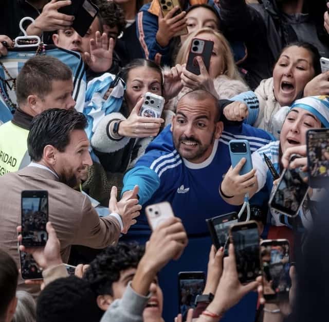 Lionel Messi saluda a hinchas que lo esperan con celulares en alto y camisetas de la Selección argentina en las calles de Oviedo (foto: prensa oficial de la AFA)