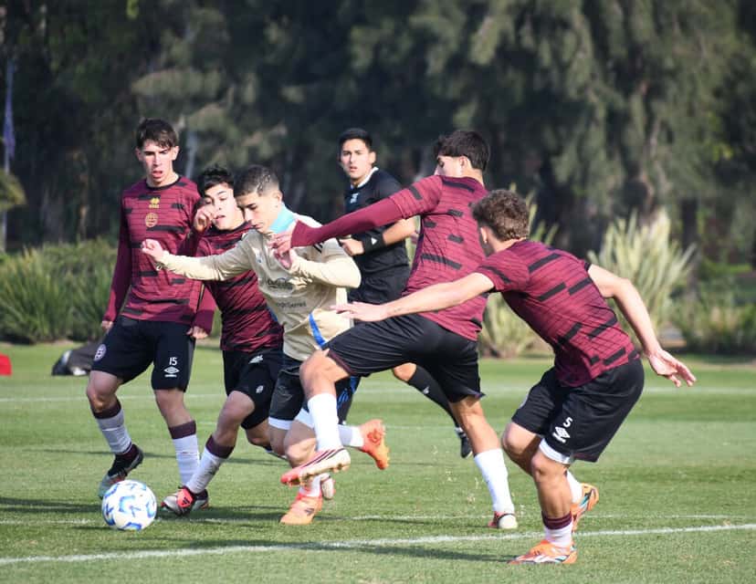 Jugadores de la preselección argentina Sub-17, con camisetas claras, disputan la pelota con futbolistas de Lanús, de camiseta bordó, en un amistoso de preparación; foto de archivo de junio de 2026 (foto: prensa oficial de la AFA)