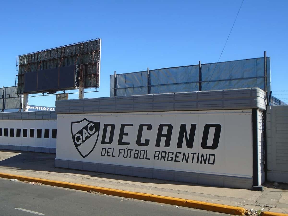 El exterior del estadio Centenario, de Quilmes, con el escudo del club y la leyenda «Decano del fútbol argentino» pintada en la pared; foto de archivo de 2021 (foto: Ulises Icardi, Wikimedia Commons, licencia CC BY-SA 4.0)
