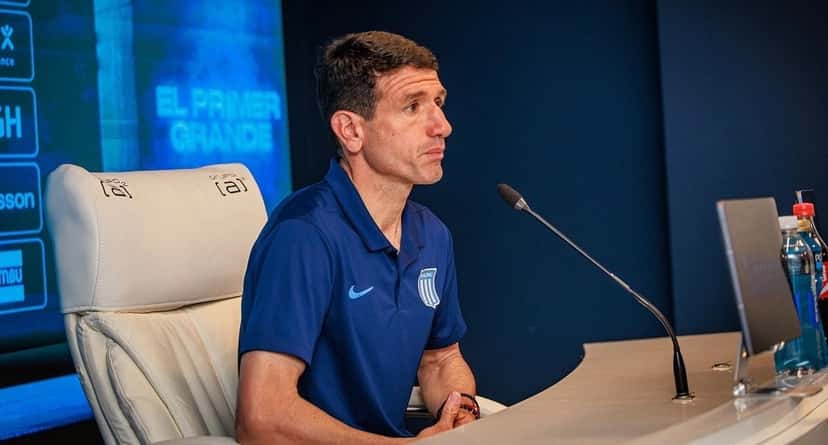 Sebastián Romero, entrenador de Racing, con una chomba azul del club, sentado frente al micrófono en la sala de conferencias del Cilindro después del clásico (foto: prensa Racing Club)