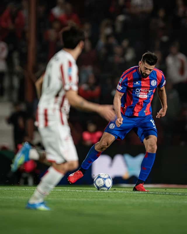 Un jugador de San Lorenzo, con la camiseta azulgrana, se prepara para patear la pelota ante un rival de camiseta blanca en un partido nocturno; foto de archivo del Clausura 2026 (foto: prensa Club Atlético San Lorenzo de Almagro)
