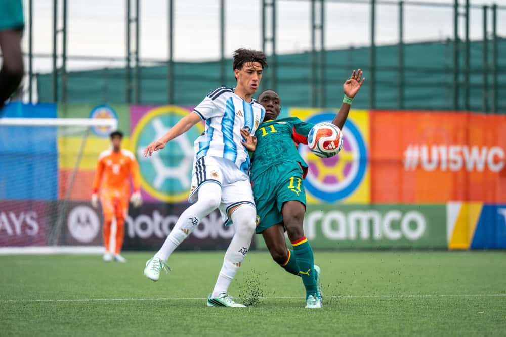 Un jugador de la Selección argentina Sub-15, con la camiseta celeste y blanca, pelea la pelota con un jugador de Senegal, de camiseta verde, en el Complejo de Competición Hovsan, en Bakú (foto: prensa oficial de la AFA)