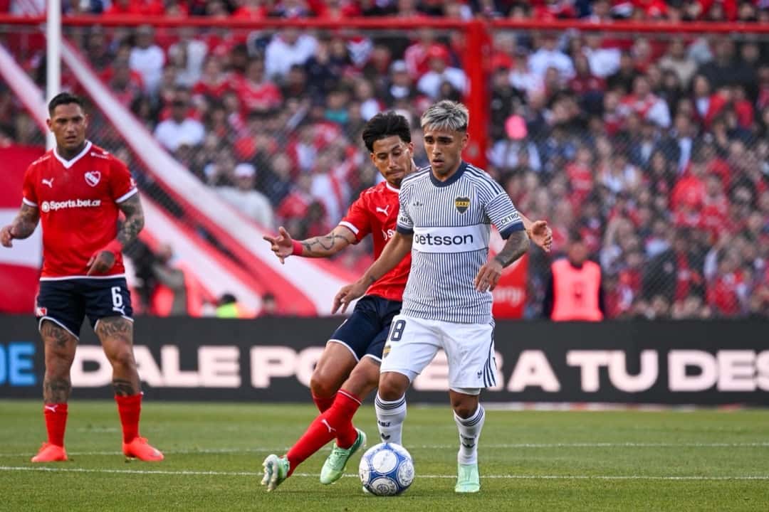 Un jugador de Boca, con la camiseta alternativa gris a rayas, maneja la pelota ante la marca de dos jugadores de Independiente, de camiseta roja; foto de archivo de octubre de 2026 (foto: prensa Liga Profesional de Fútbol)