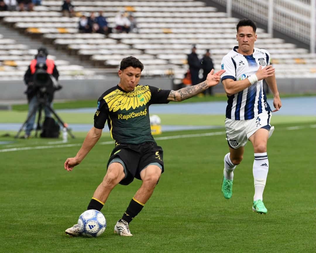 Un jugador de Defensa y Justicia, con la camiseta negra y amarilla, maneja la pelota ante la marca de un jugador de Talleres en el Kempes, el sábado 24 (foto: prensa Liga Profesional de Fútbol)