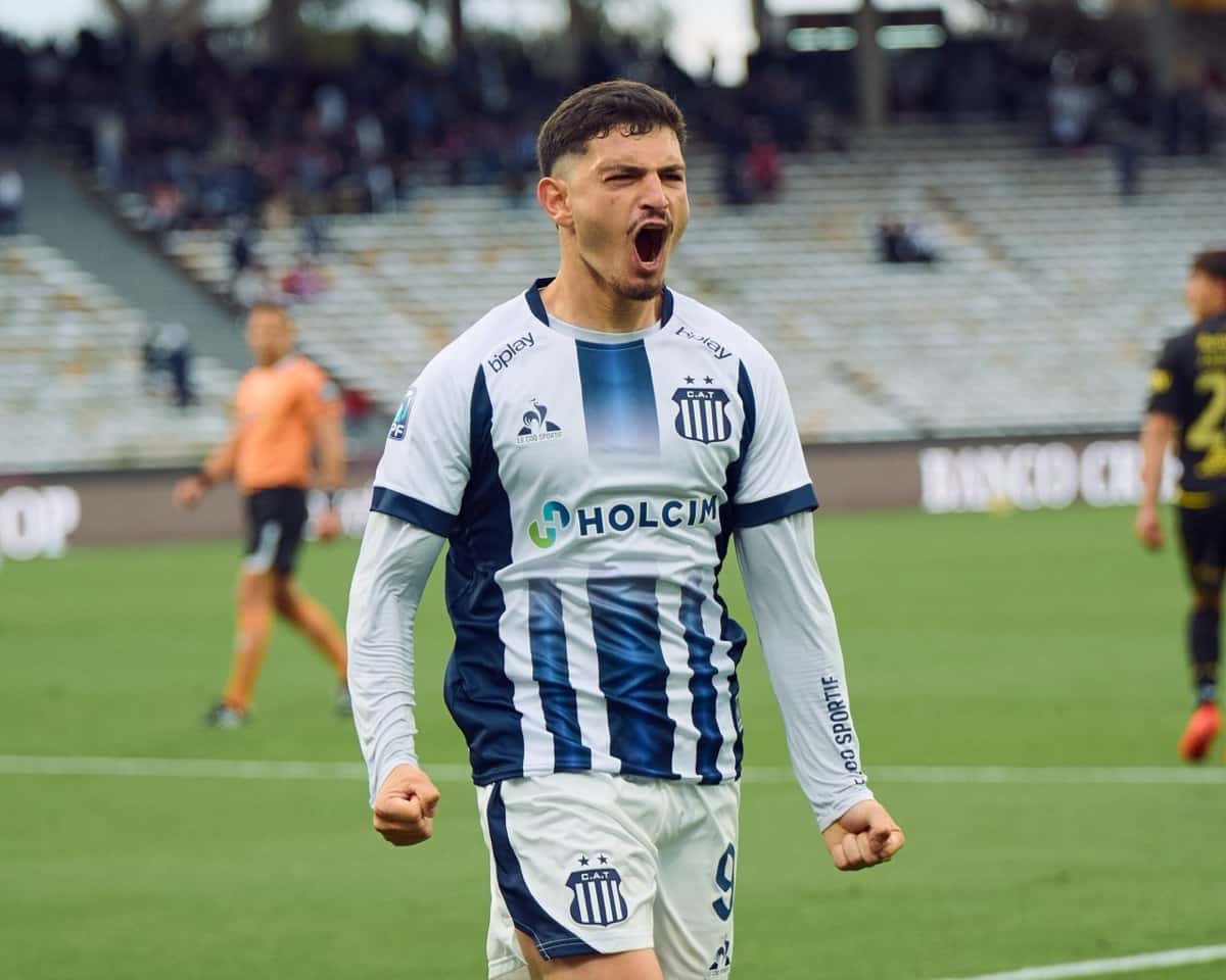 Agustín Álvarez Martínez, con la camiseta azul y blanca de Talleres, grita con los puños apretados para festejar su gol ante Defensa y Justicia en el Kempes (foto: prensa Liga Profesional de Fútbol)