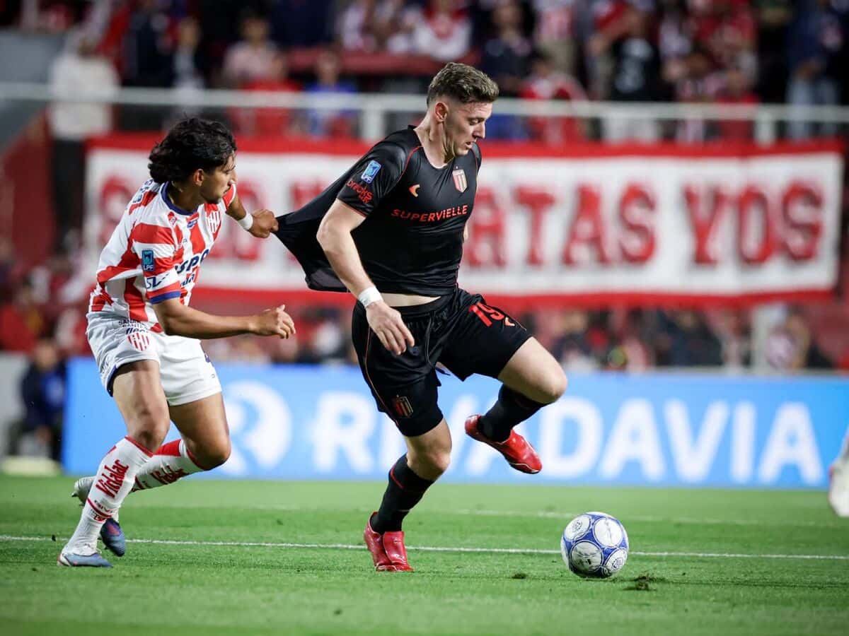 Un jugador de Estudiantes, con la camiseta negra, protege la pelota ante un futbolista de Unión, con la camiseta rojiblanca, en el estadio 15 de Abril (foto: prensa oficial de Estudiantes de La Plata)