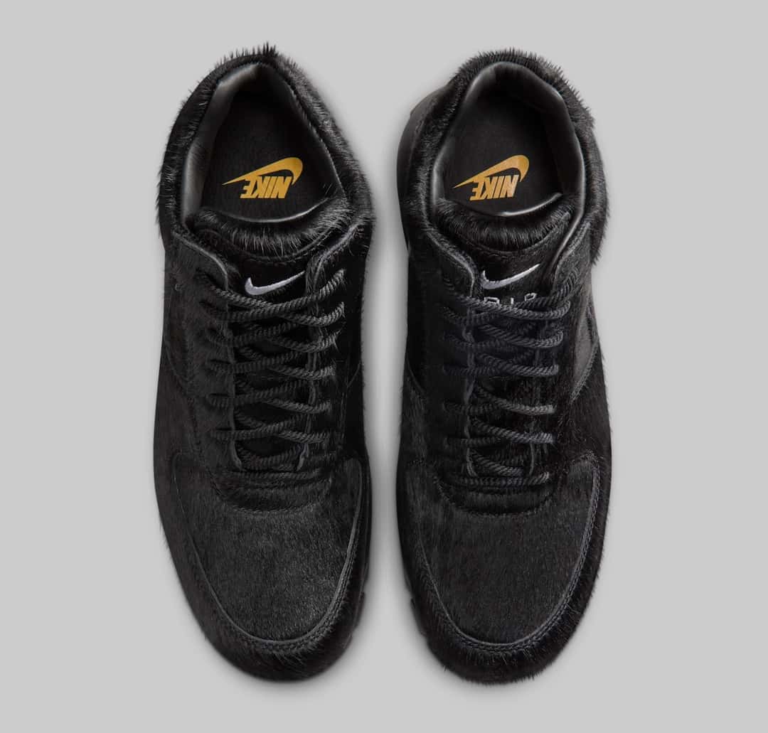 Par de Nike Air Max Goadome Black Pony Hair visto desde arriba sobre fondo gris, con la plantilla negra y el logo de Nike en dorado