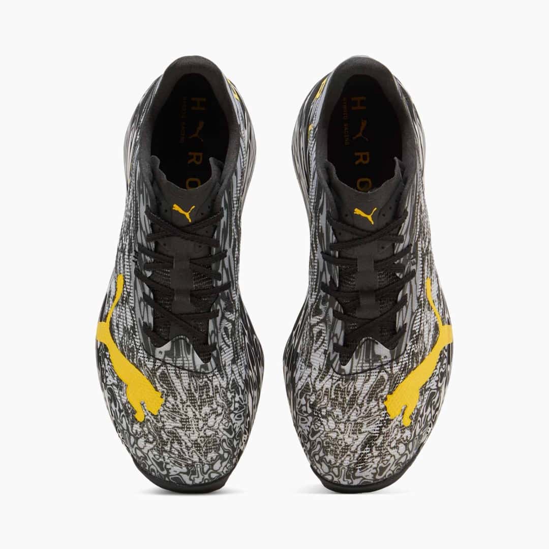 Par de Puma Hybrid RCN HYROX Nitro Elite Camo visto desde arriba, con el estampado blanco y negro y los logos amarillos