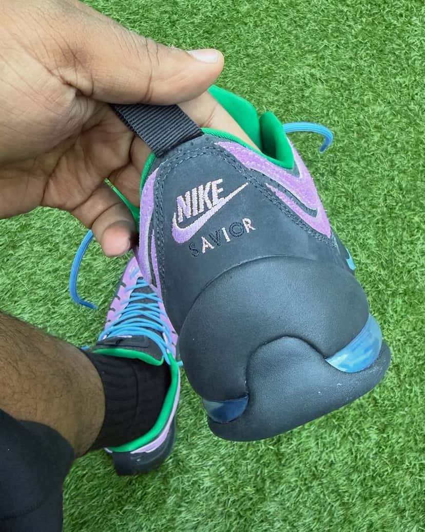 Talón del Jae Tips x Nike Air Bakin Low Purple Stardust en negro con el logo Nike y la palabra SAVIOR bordados en violeta y la cámara de aire a la vista