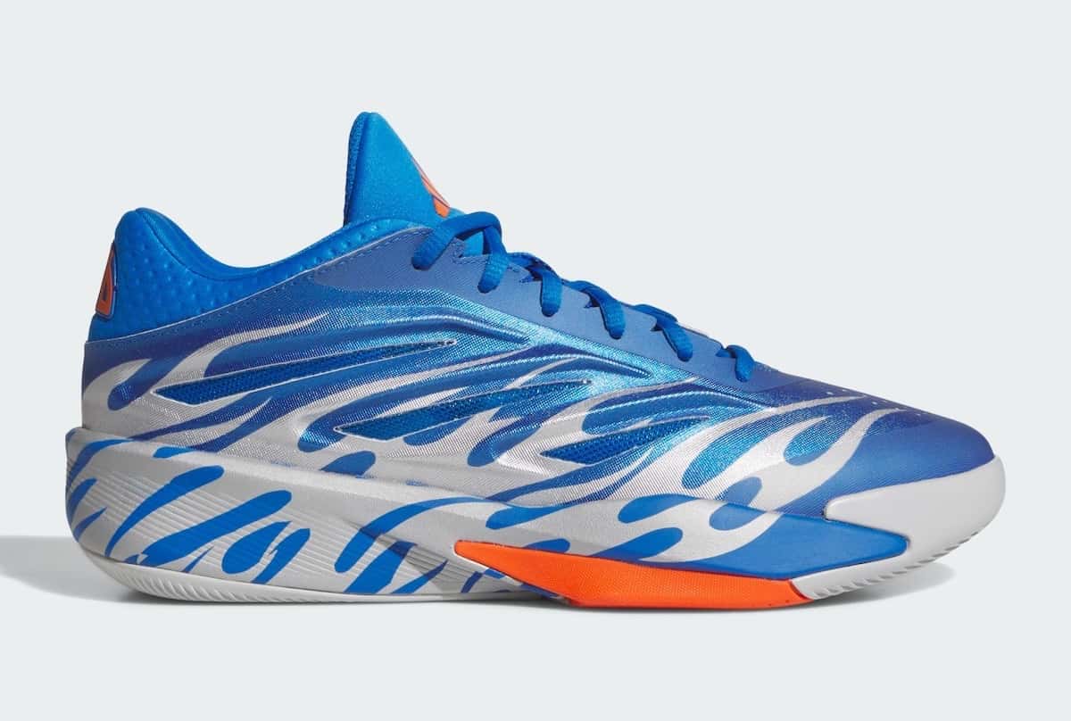 adidas Crazy Energy Flames de Jalen Williams de perfil, en azul metalizado con llamas plateadas en el costado y un detalle naranja en la mediasuela, sobre fondo gris claro