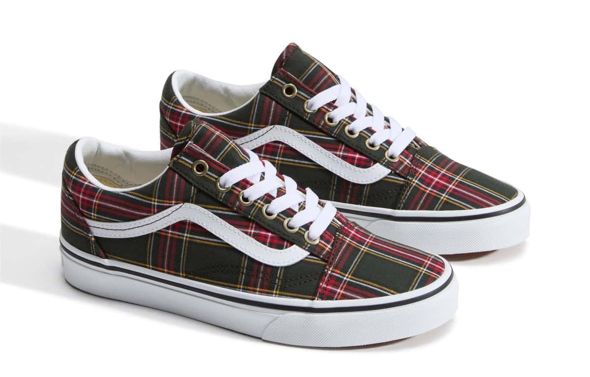 Par de Vans Old Skool con capellada escocesa verde, roja y amarilla, la franja lateral blanca y suela blanca sobre fondo blanco