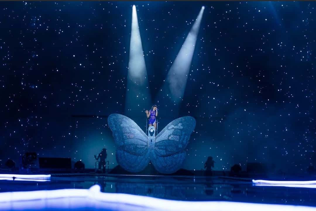 El escenario del Cuarto Azul World Tour a oscuras, con una enorme mariposa celeste en el centro, dos haces de luz blanca desde arriba y un fondo azul lleno de estrellas (foto de archivo de la gira)