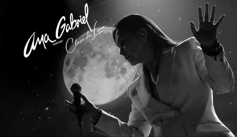 Afiche oficial de la gira «Claro de Luna» 2027 de Ana Gabriel: la cantante en blanco y negro, de saco claro, con la mano levantada frente a una luna llena