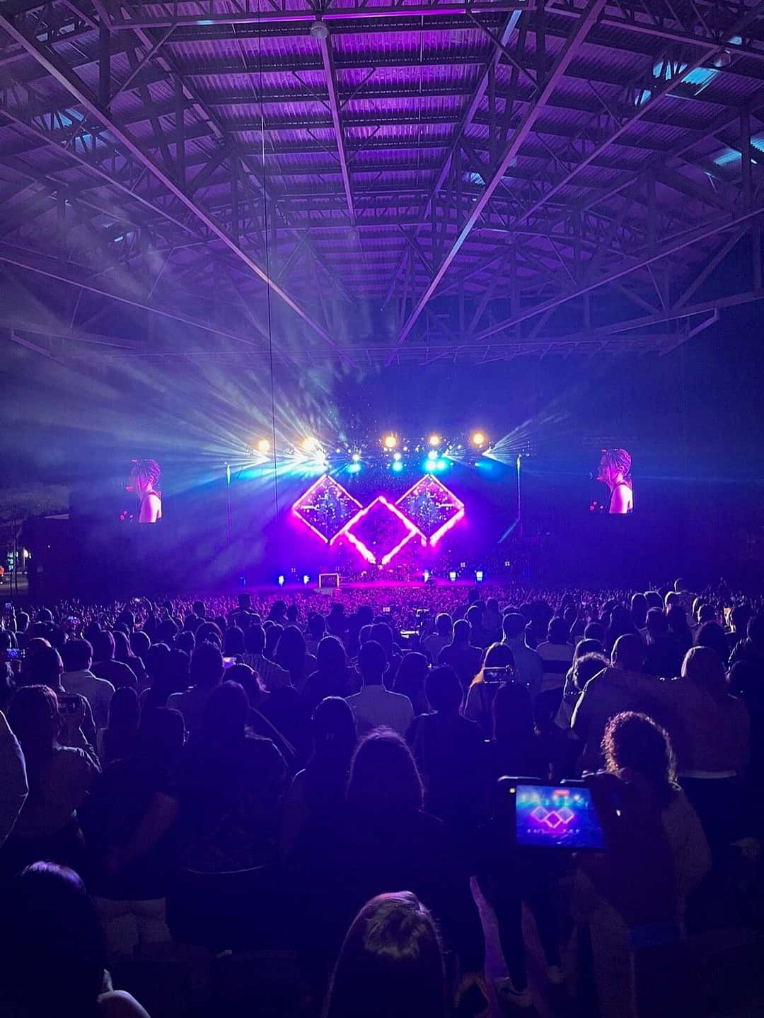 Escenario iluminado con luces violetas y pantallas en forma de rombo durante un concierto de Jesse & Joy en Parque Viva, Costa Rica, con el público en primer plano (foto de archivo, 2023). Foto: LuchoCR, CC BY-SA 4.0, vía Wikimedia Commons