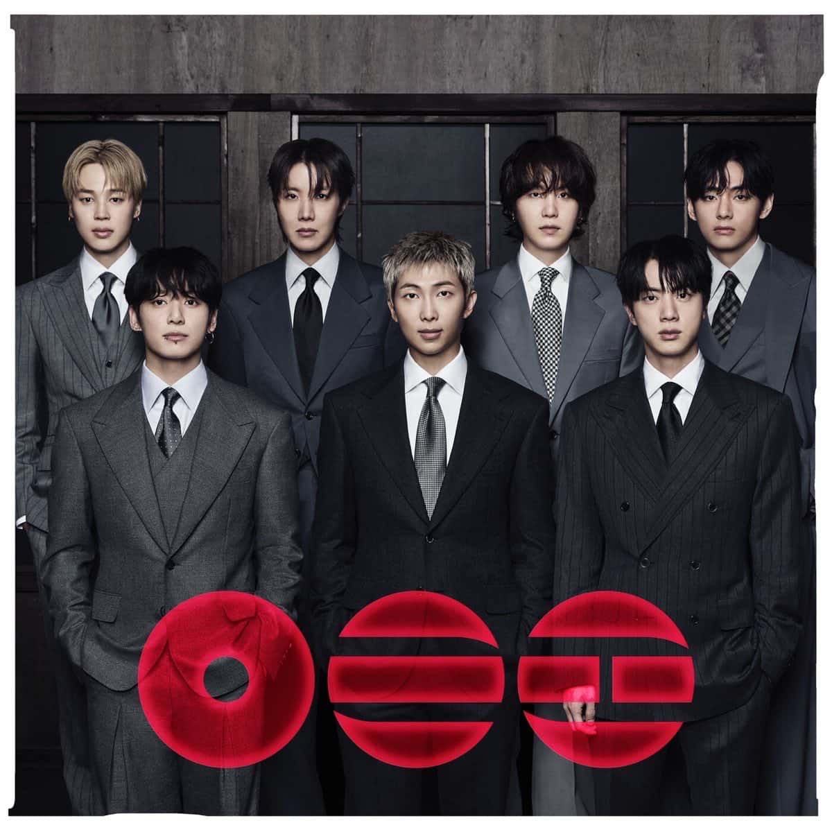 Portada de «ARIRANG», el disco de BTS: los siete integrantes de traje gris frente a una pared de madera oscura, con el título en letras coreanas rojas en primer plano