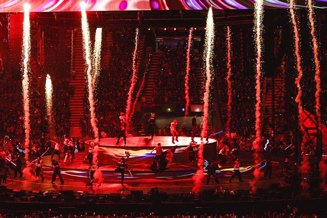 Vista del Estadio Único de La Plata durante el show de BTS, con columnas de fuego sobre el escenario circular y el campo iluminado en rojo. Foto: HYBE/BIGHIT MUSIC