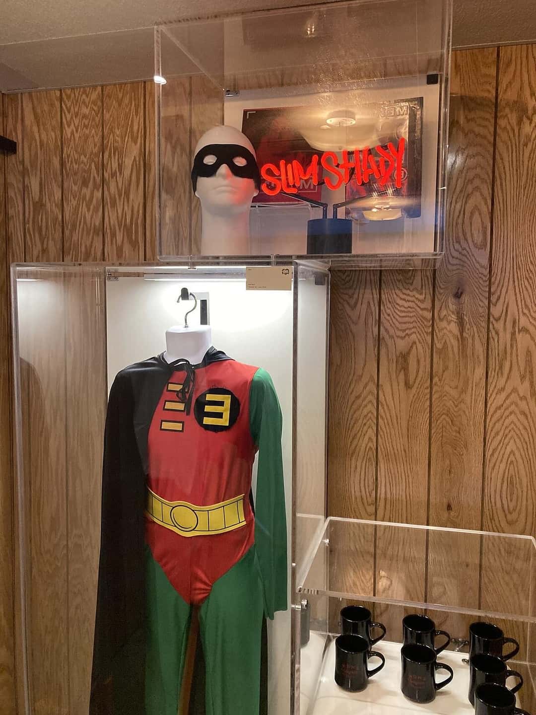 Vitrina dentro de Mom's Spaghetti con el traje de Robin con la letra E que Eminem usó en el video de «Without Me», una máscara y un cartel de neón rojo que dice «Slim Shady» (foto de archivo, noviembre de 2021). Foto: The lorax, CC0, vía Wikimedia Commons