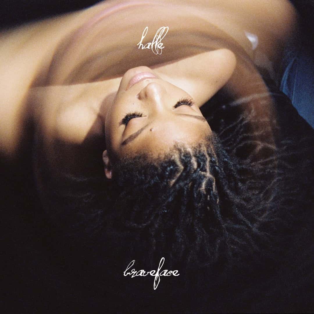 Portada del single «braveface», de Halle Bailey: la cantante recostada, con los ojos cerrados, en una foto en tonos cálidos