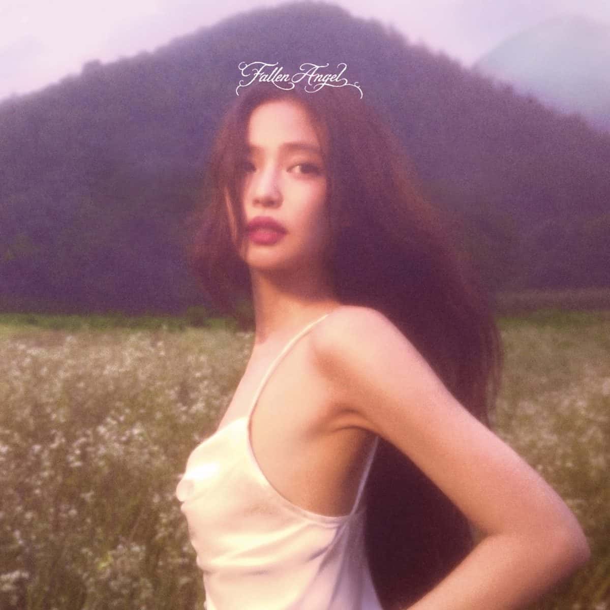 Portada de «Fallen Angel», de JENNIE: la cantante, con un vestido claro de breteles y el pelo suelto, en un campo de flores blancas frente a una montaña cubierta de niebla