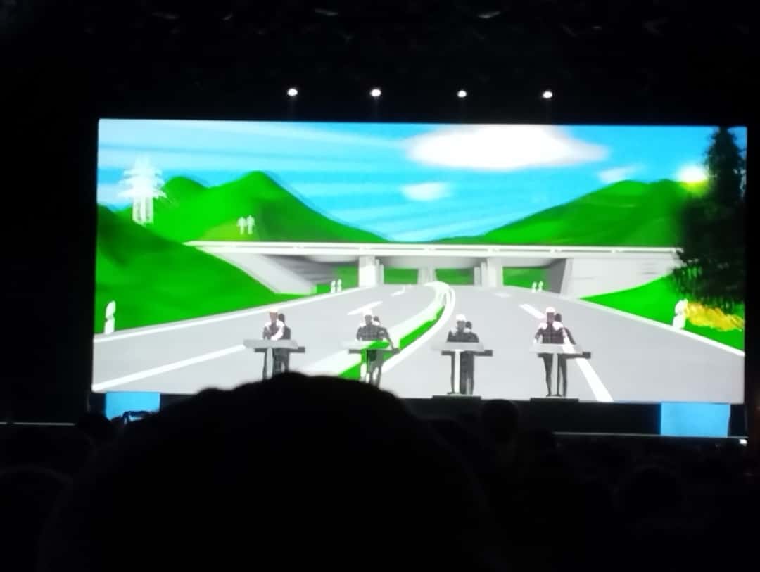 Kraftwerk en vivo en Rock en Seine, en las afueras de París, en agosto de 2022: los cuatro integrantes detrás de sus consolas, chiquitos frente a una pantalla gigante con una autopista que atraviesa un paisaje de colinas verdes, durante «Autobahn» (foto de archivo). Foto: ManoSolo13241324, CC BY-SA 4.0, vía Wikimedia Commons