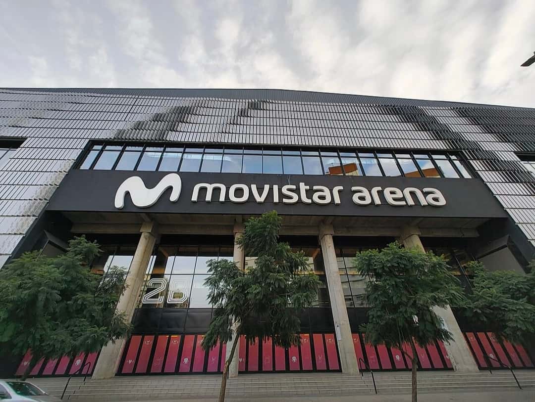 Fachada del Movistar Arena de Buenos Aires, con su cartel sobre la entrada y árboles en la vereda (foto de archivo, junio de 2025). Foto: BugWarp, CC BY-SA 4.0, vía Wikimedia Commons